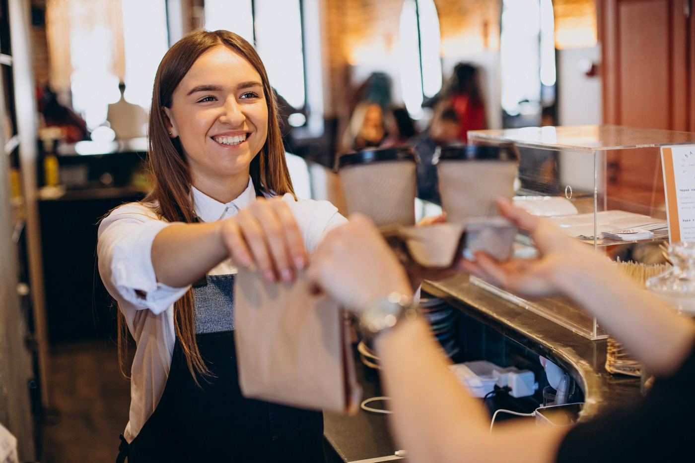 Barista entregando un pedido a una clienta habitual