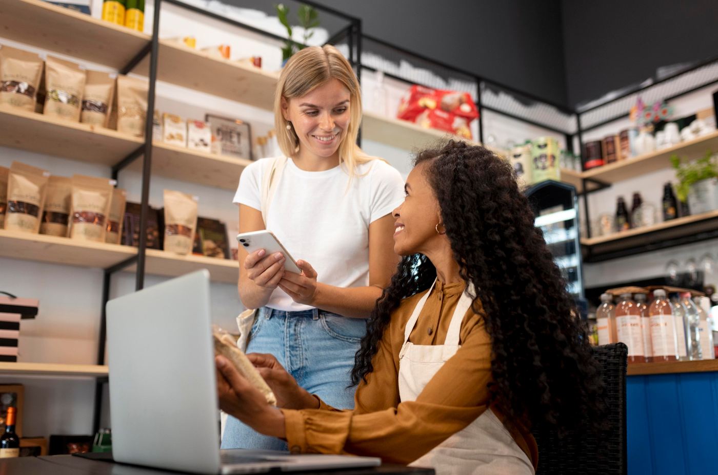 Dueñas de una tienda revisando su comunidad en el celular